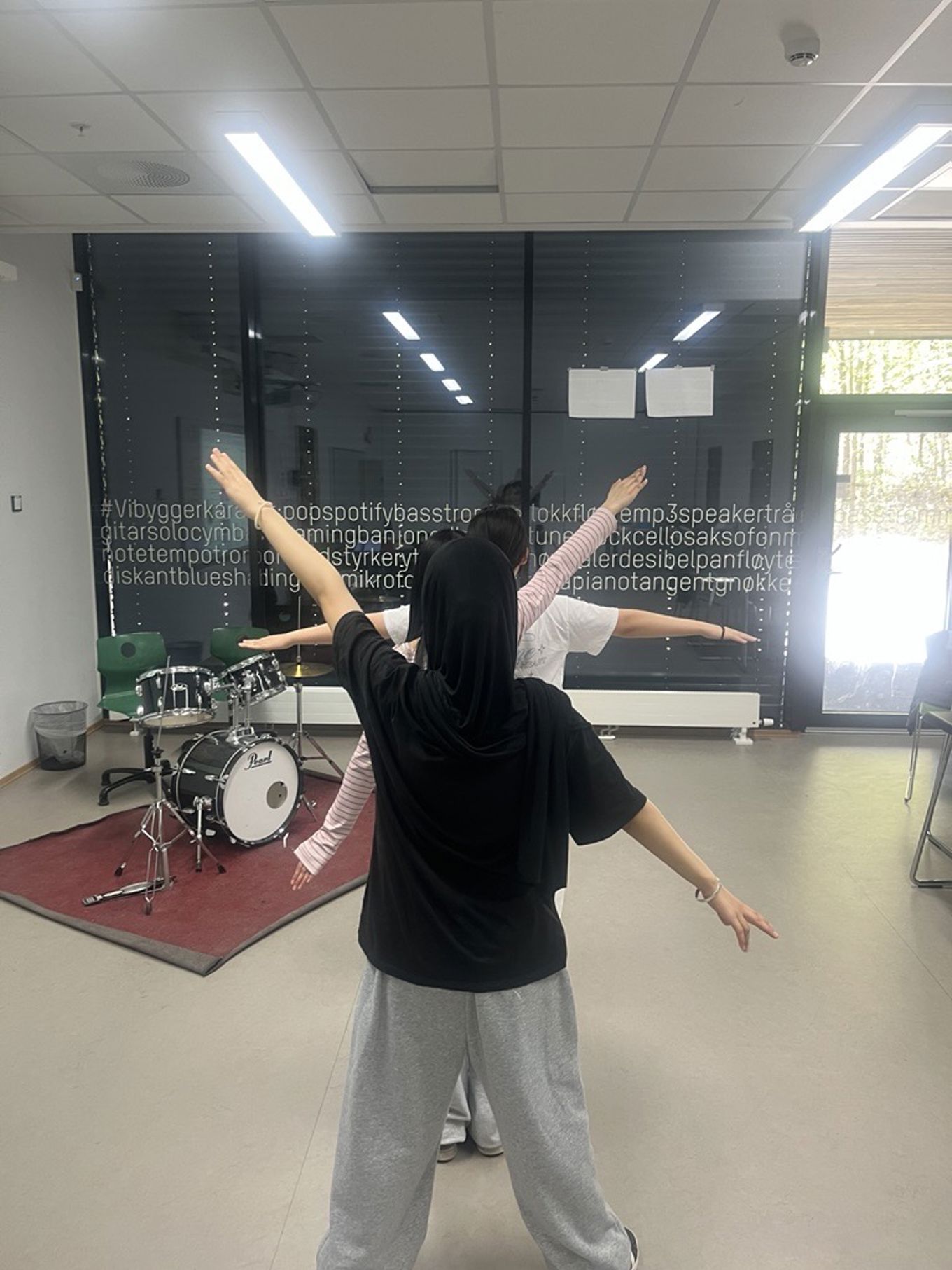 a person holding a person's hand in a room with a drum set and speakers