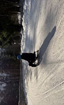 En person som kjører snowboard ned en snødekt bakke