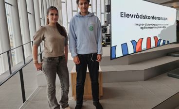 en person og en person som står foran et skilt