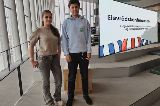 en person og en person som står foran et skilt