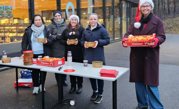 en gruppe mennesker som står rundt et bord med mat på