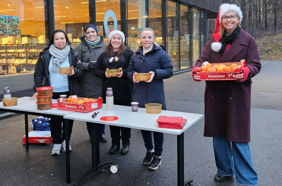en gruppe mennesker som står rundt et bord med mat på