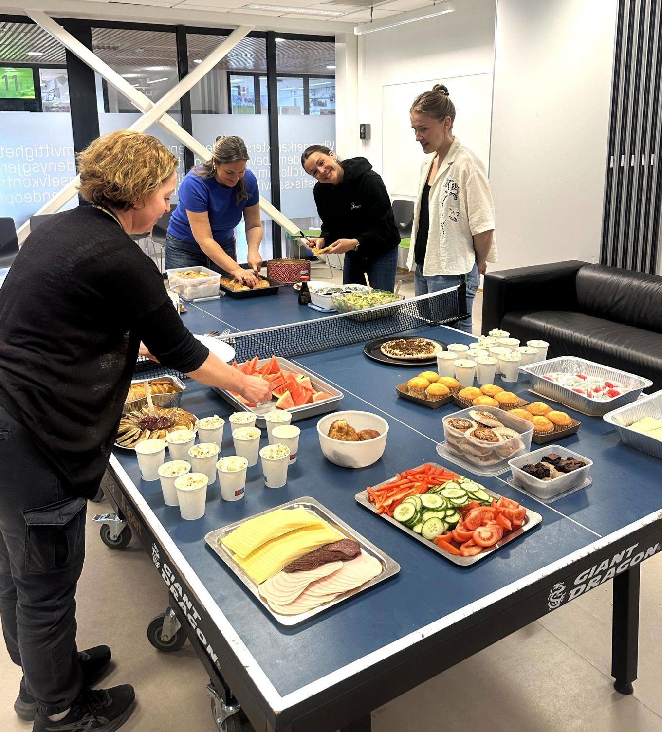 en gruppe mennesker som står rundt et bord med mat på