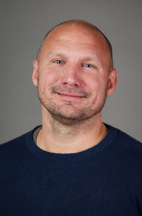 en skallet person i blå skjorte