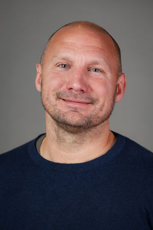 en skallet person i blå skjorte