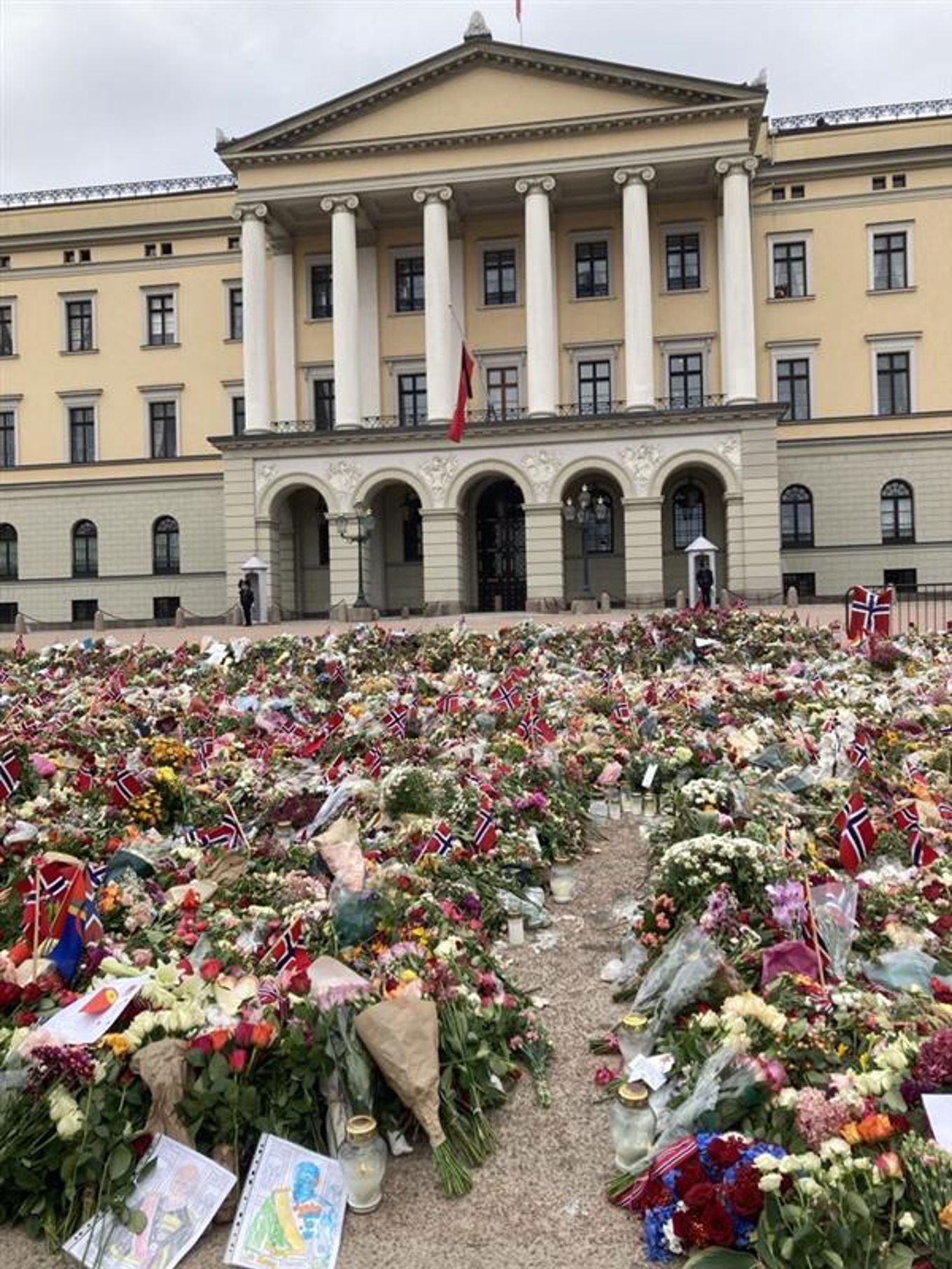 en stor bygning med mange blomster foran seg en stor bygning med mange blomster foran seg