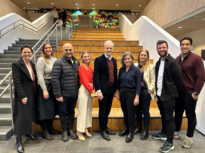 En gruppe mennesker som poserer for et bilde foran trappen